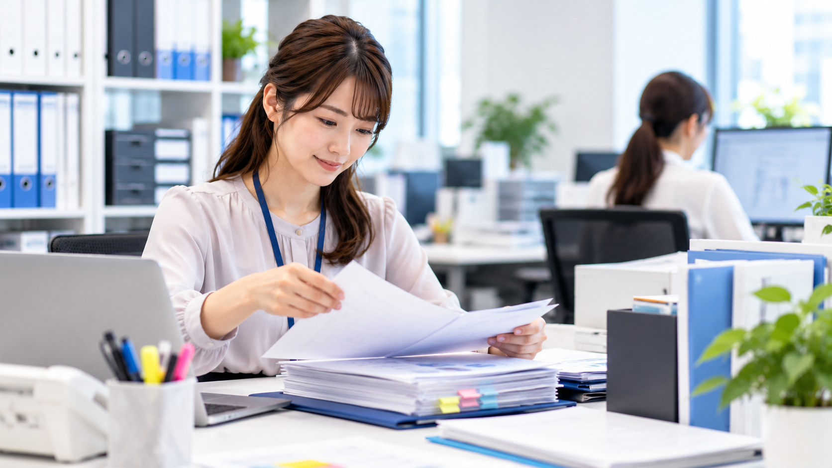 書類を整理する明るいオフィスの女性